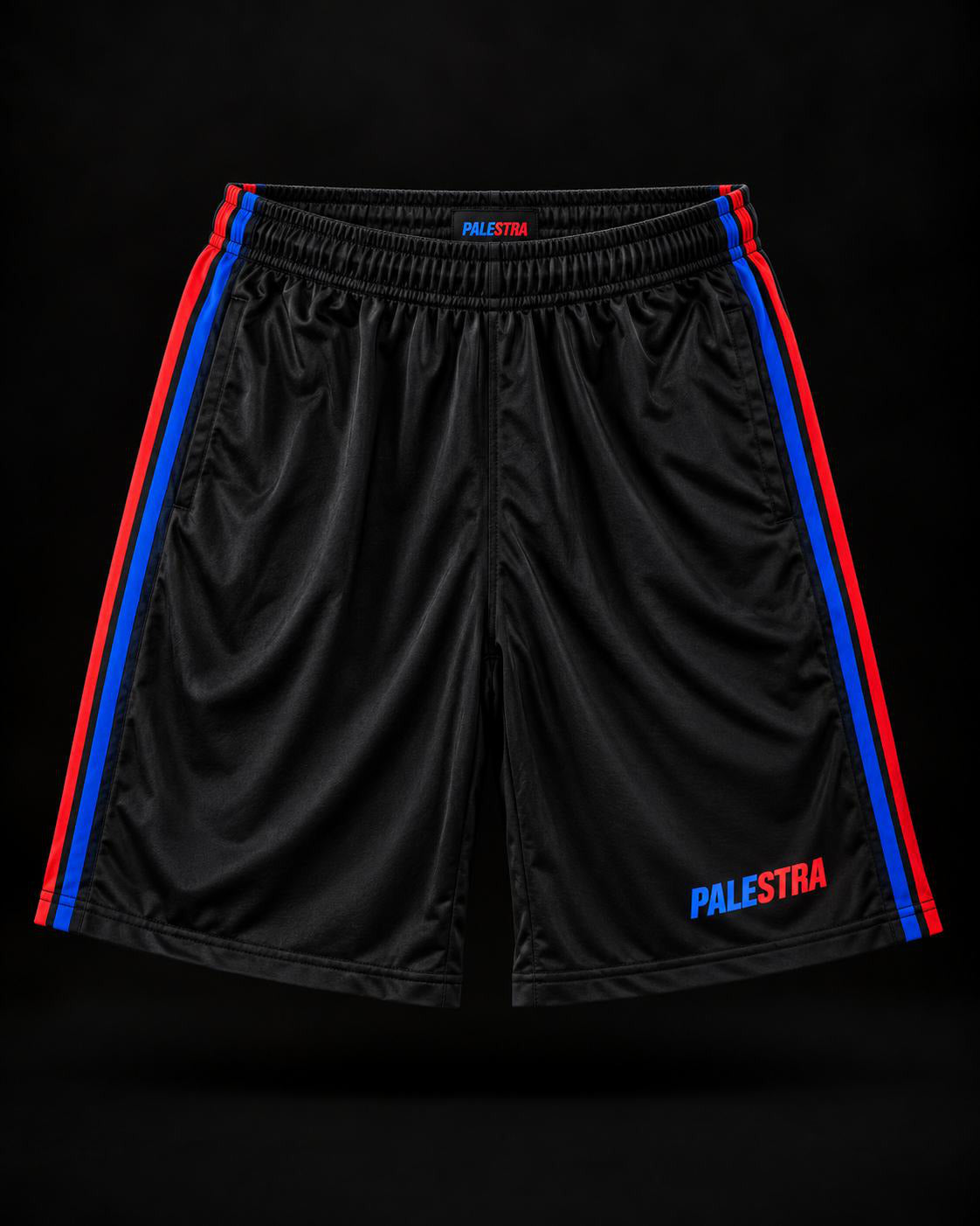 Black PALESTRA shorts with blue and red side stripes, front view on a dark background