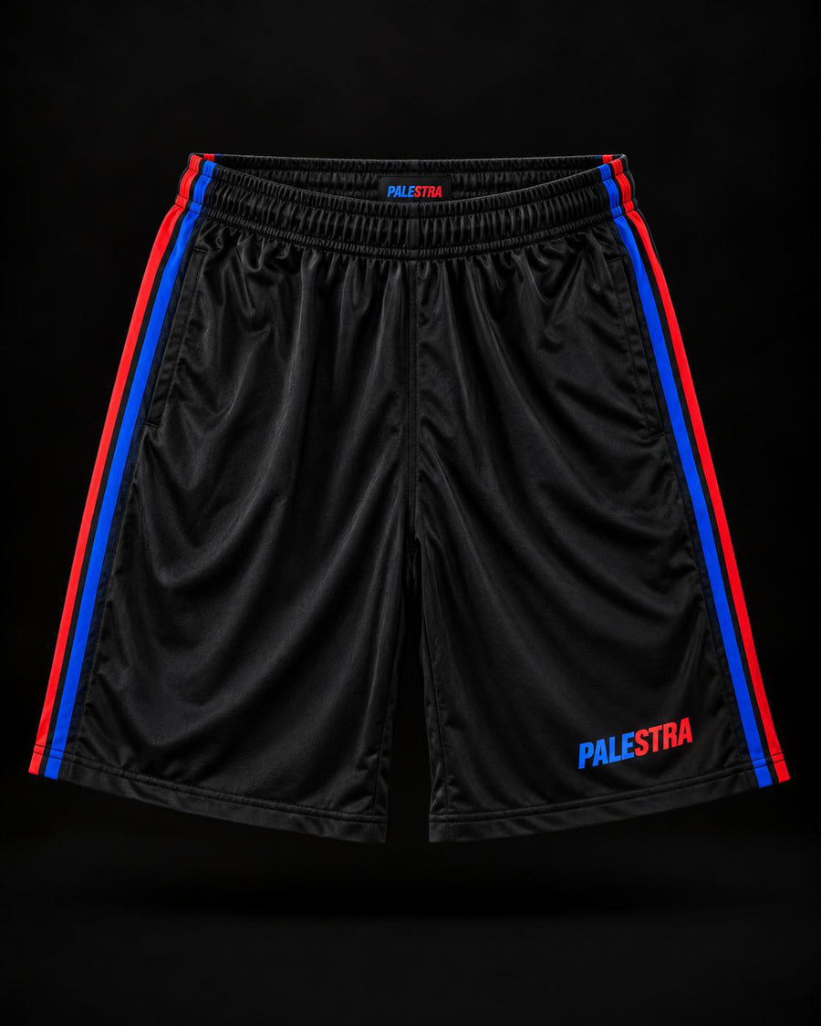 Black PALESTRA shorts with blue and red side stripes, front view on a dark background