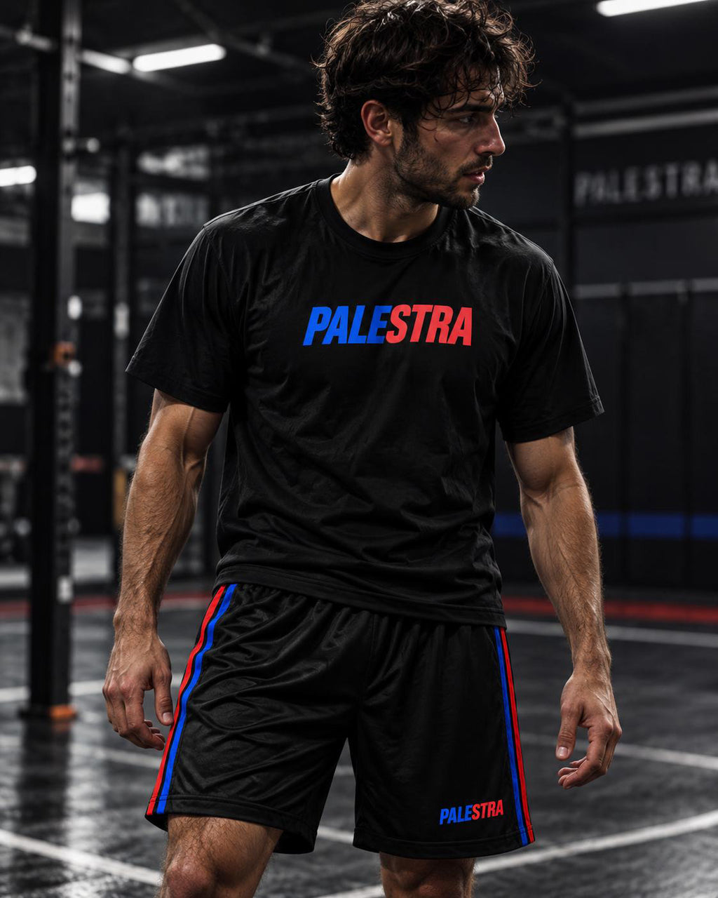 Athlete wearing black PALESTRA shorts with blue and red side stripes